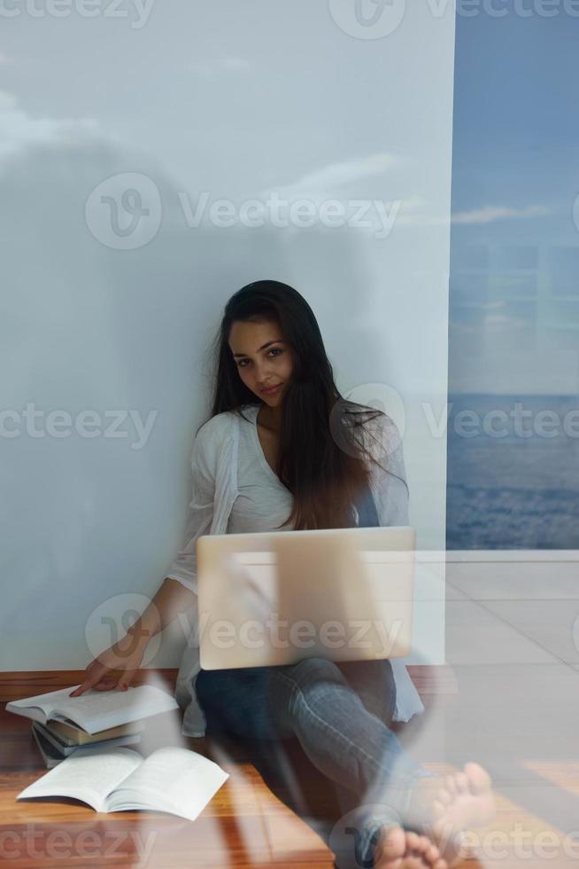 relaxed young woman at home working on laptop computer photo