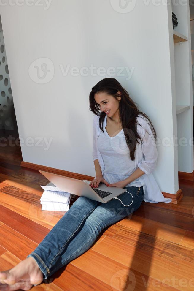 relaxed young woman at home working on laptop computer photo