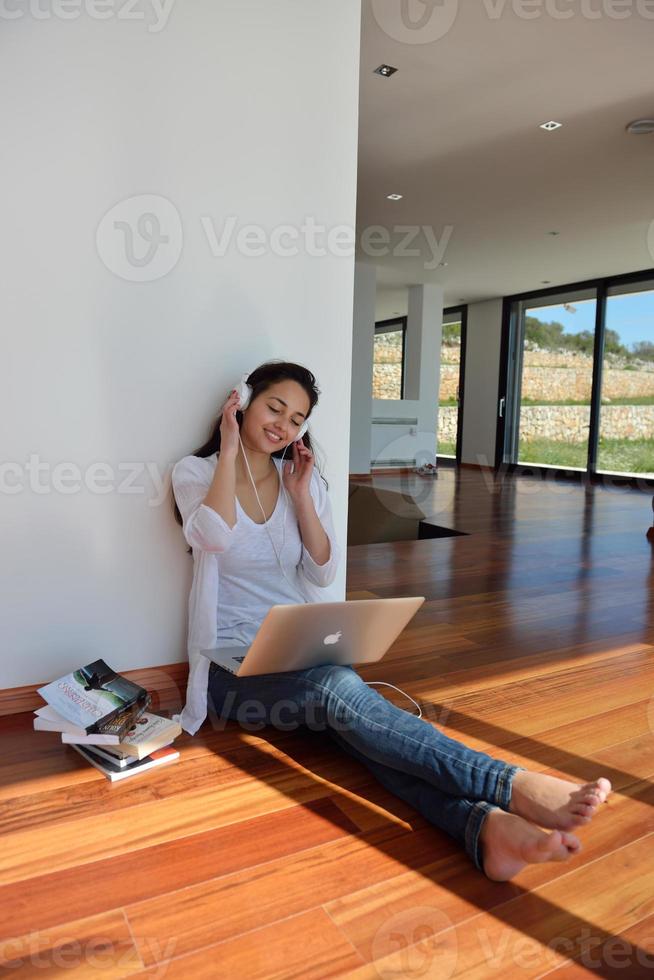 mujer joven relajada en casa trabajando en una laptop foto