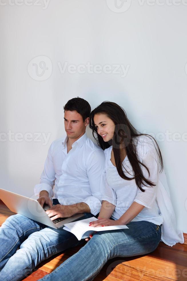 relaxed young couple working on laptop computer at home photo