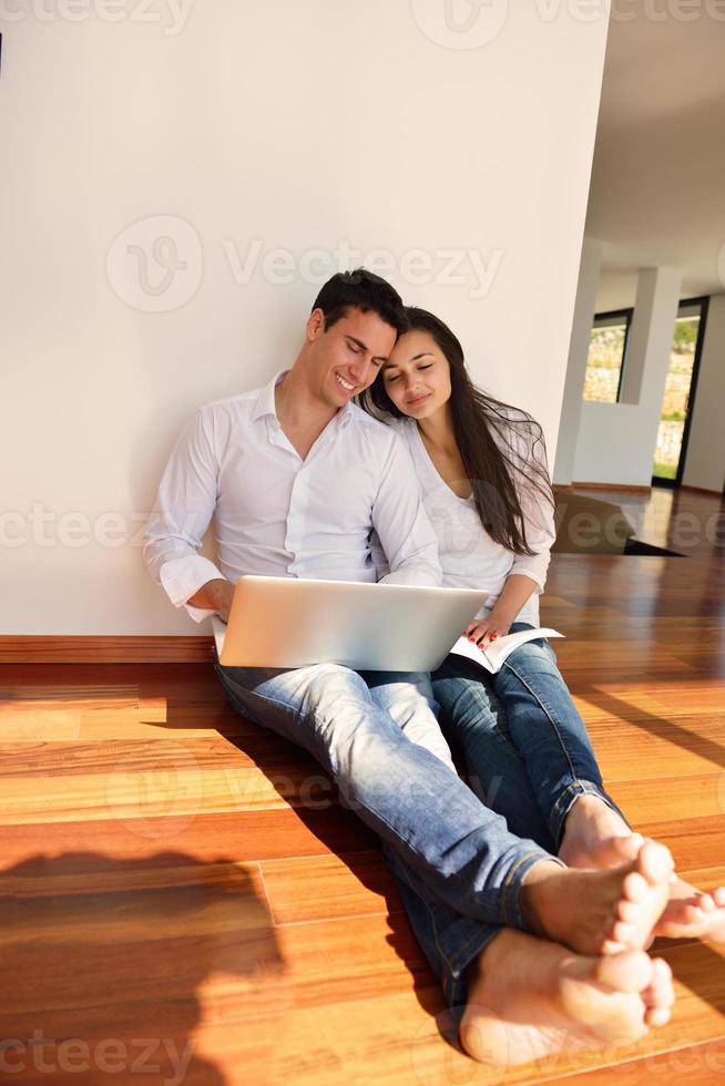 relaxed young couple working on laptop computer at home photo