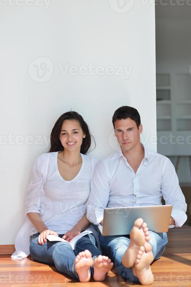 relaxed young couple working on laptop computer at home photo