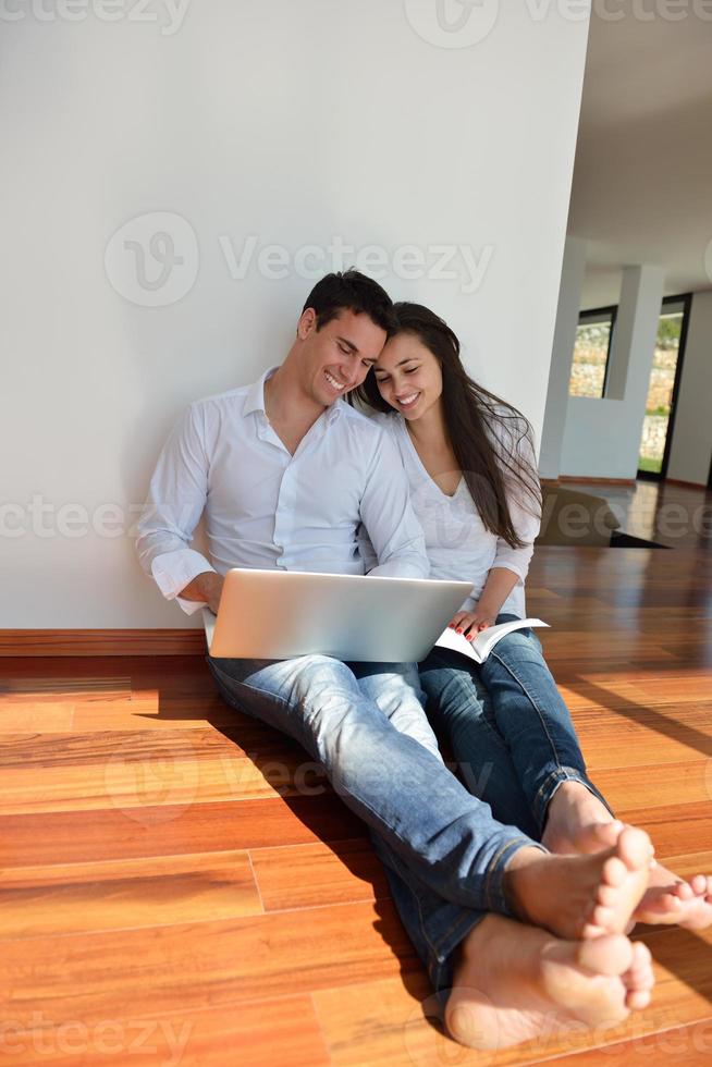 relaxed young couple working on laptop computer at home photo