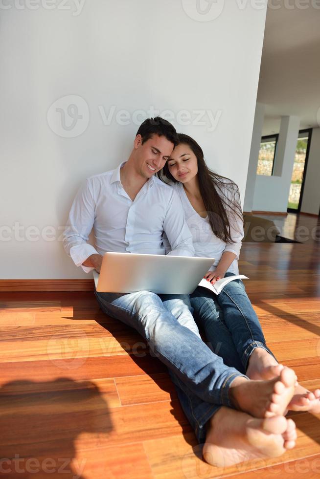relaxed young couple working on laptop computer at home photo