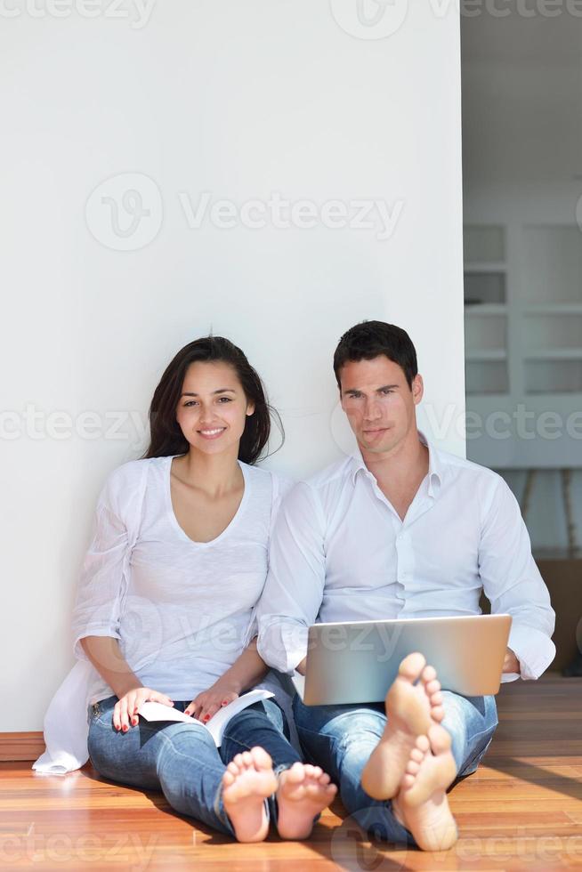 relaxed young couple working on laptop computer at home photo