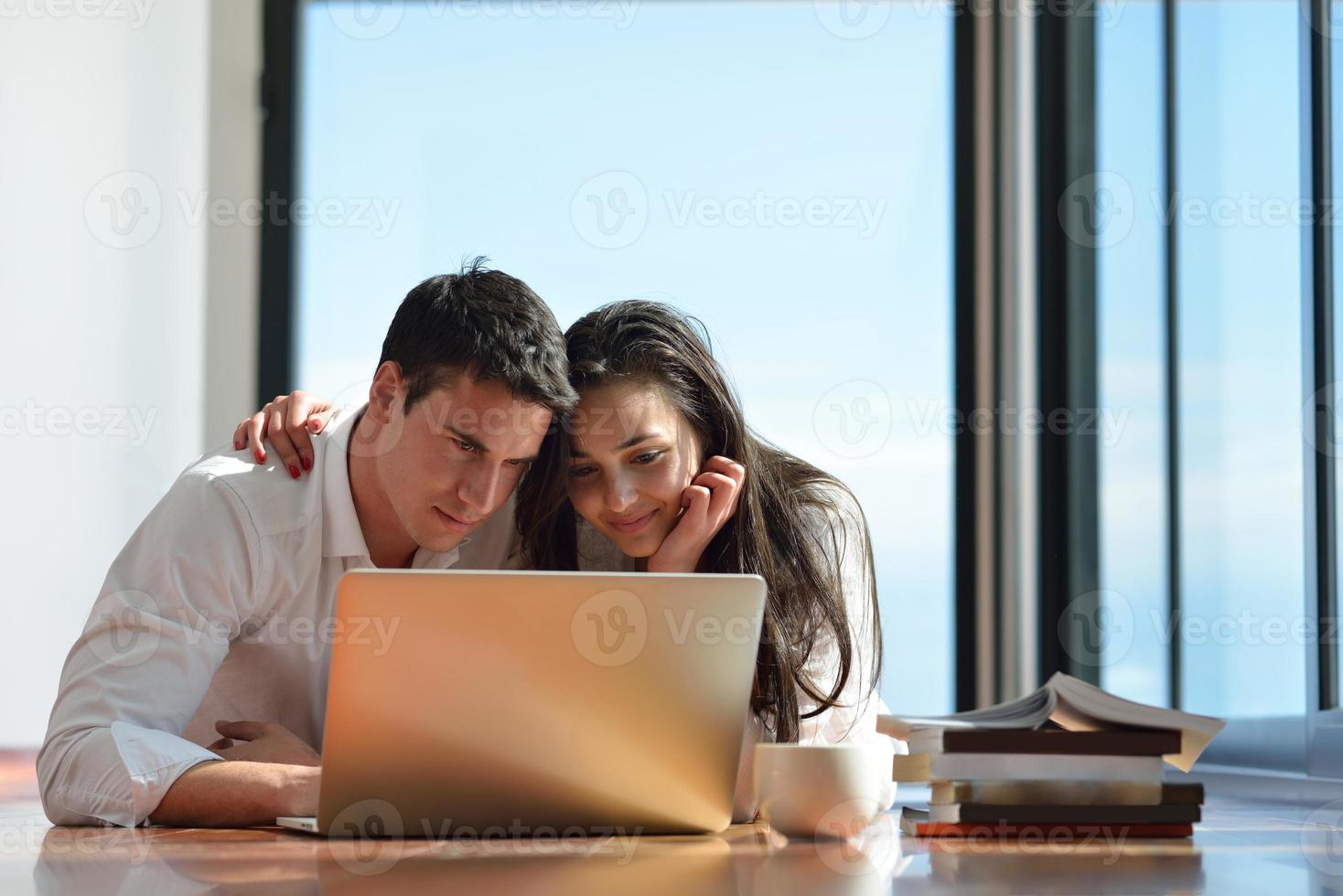 relaxed young couple working on laptop computer at home photo
