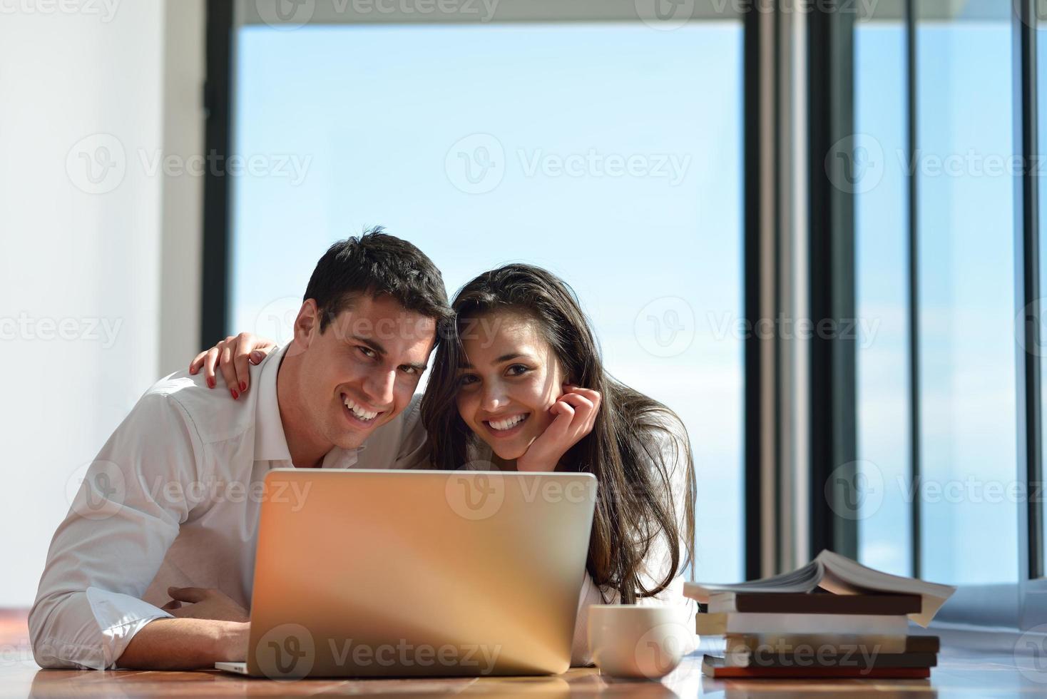 relaxed young couple working on laptop computer at home photo