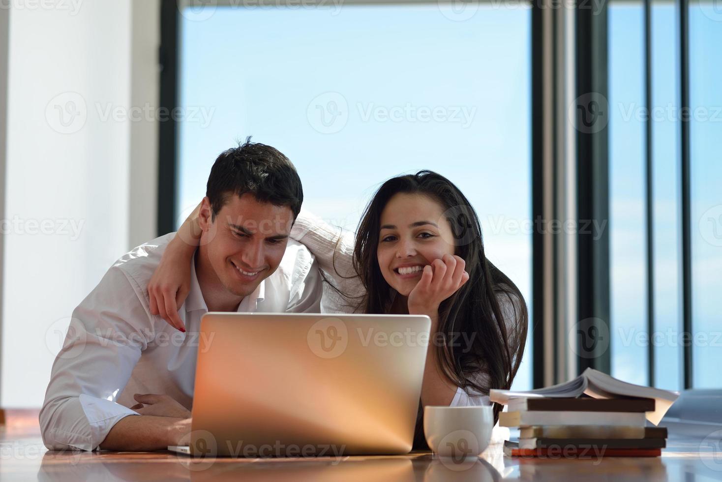 relaxed young couple working on laptop computer at home photo