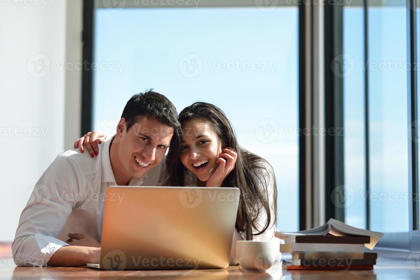relaxed young couple working on laptop computer at home photo
