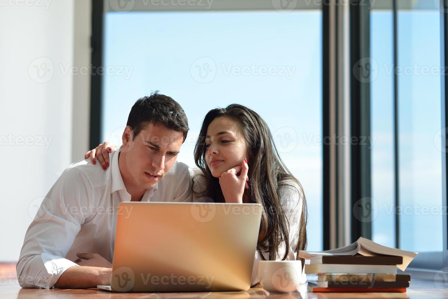 relaxed young couple working on laptop computer at home photo