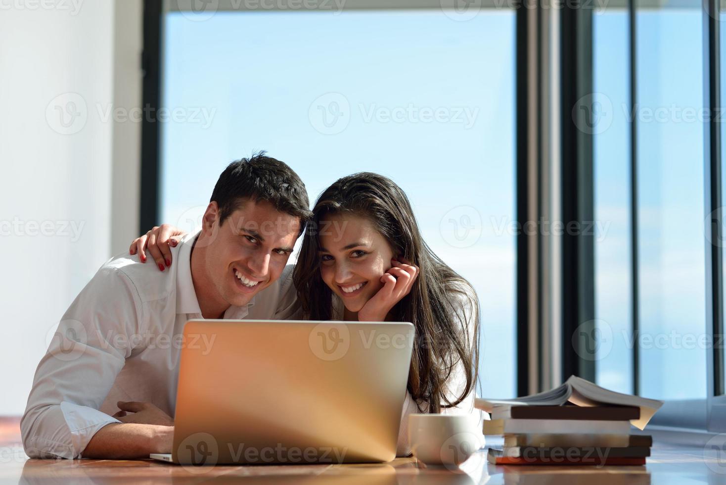 relaxed young couple working on laptop computer at home photo