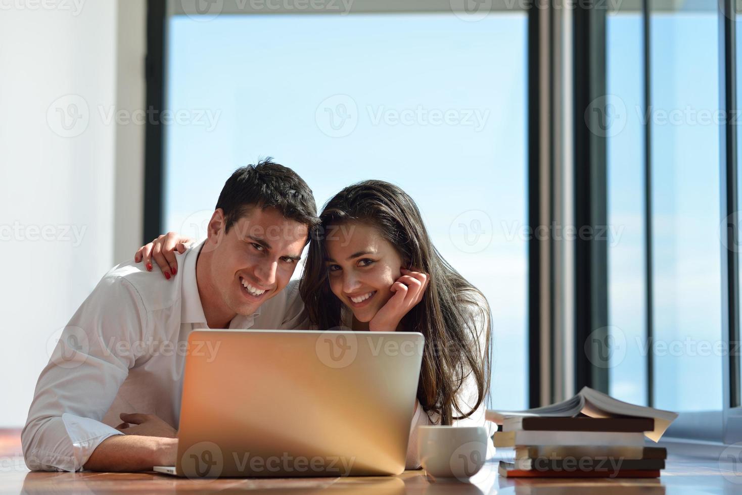 relaxed young couple working on laptop computer at home photo