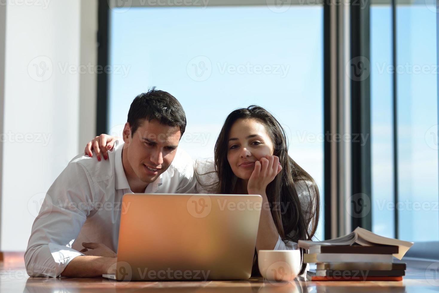 relaxed young couple working on laptop computer at home photo