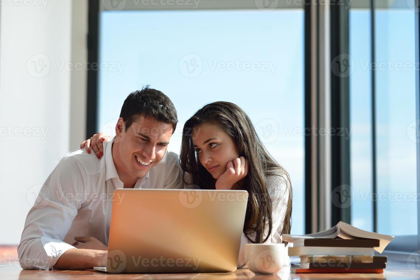 relaxed young couple working on laptop computer at home photo