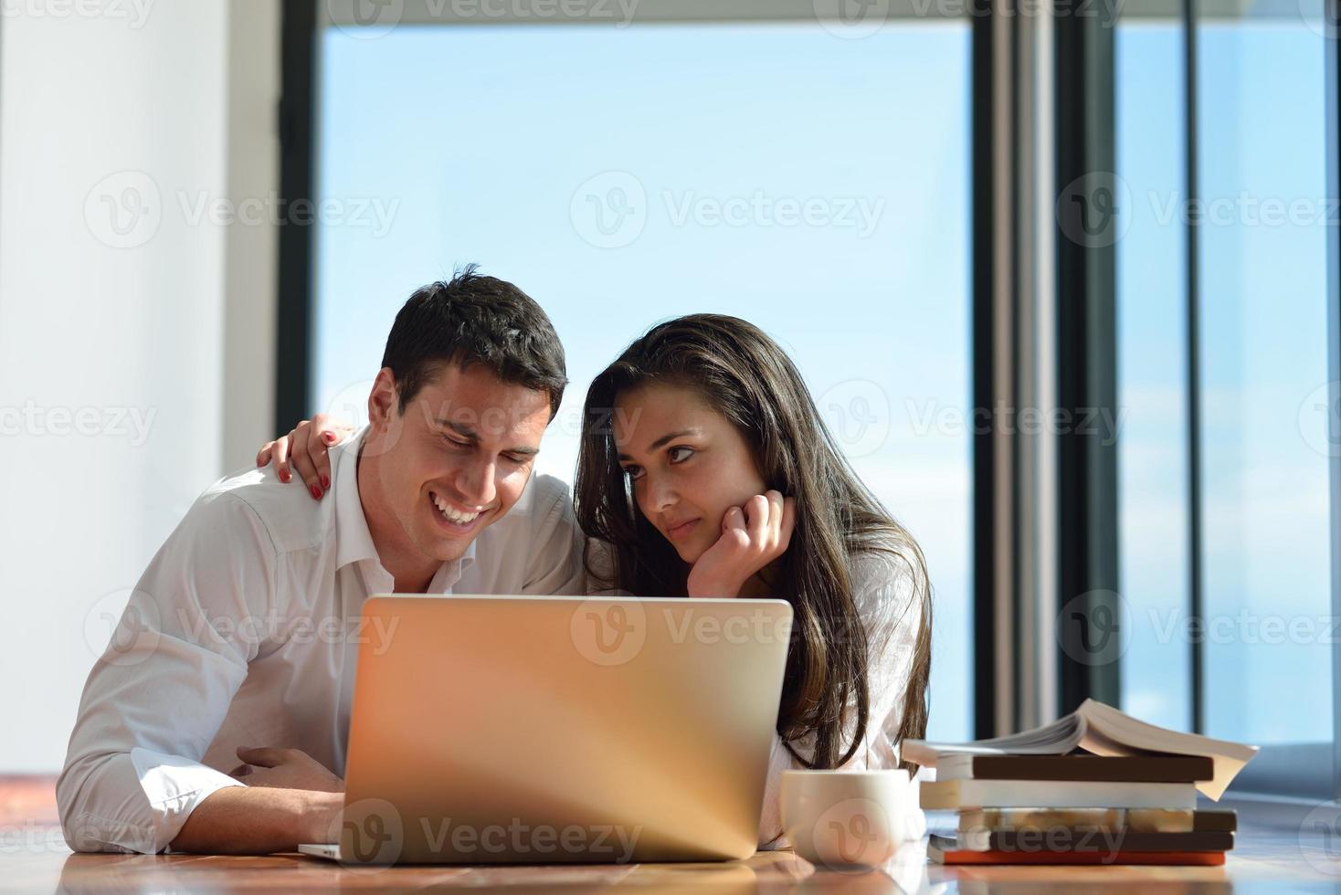 relaxed young couple working on laptop computer at home photo