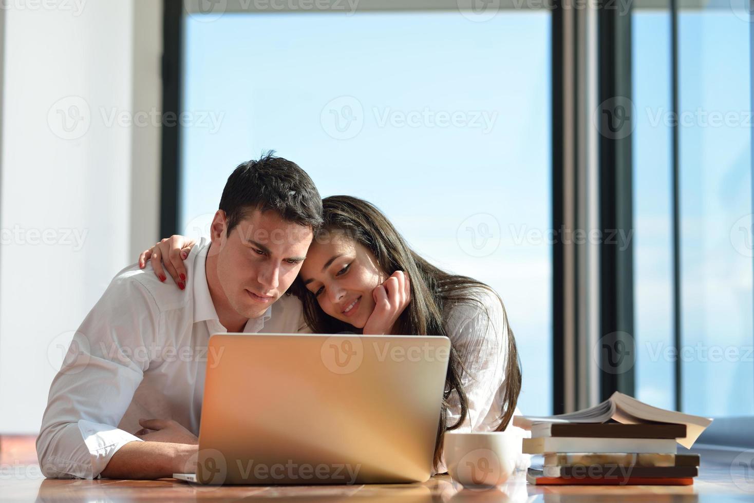relaxed young couple working on laptop computer at home photo