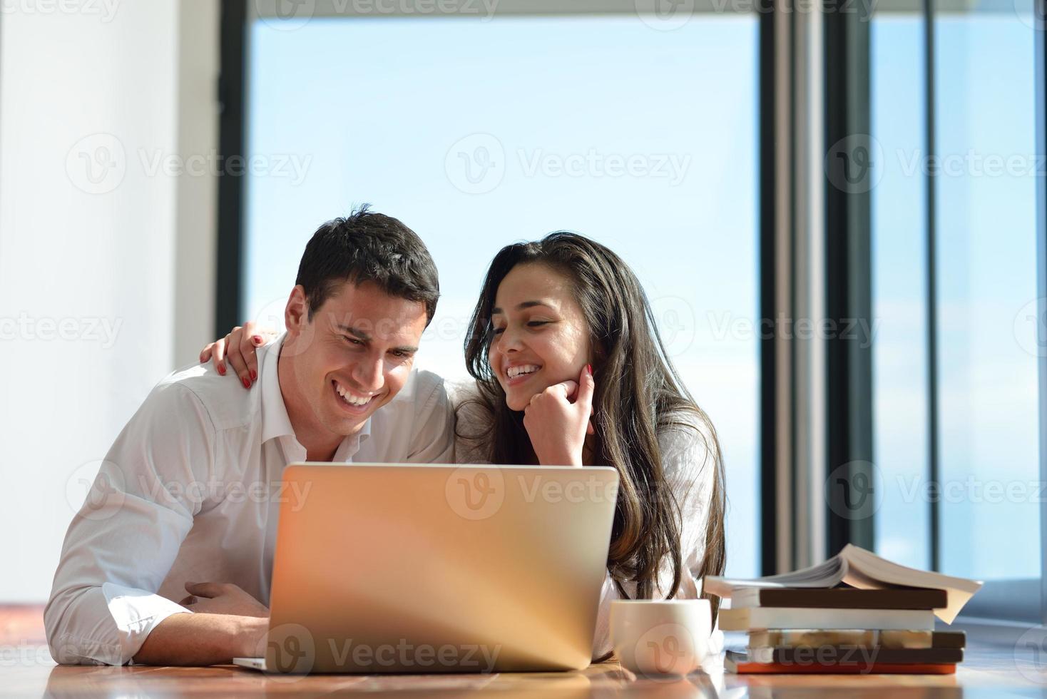 relaxed young couple working on laptop computer at home photo
