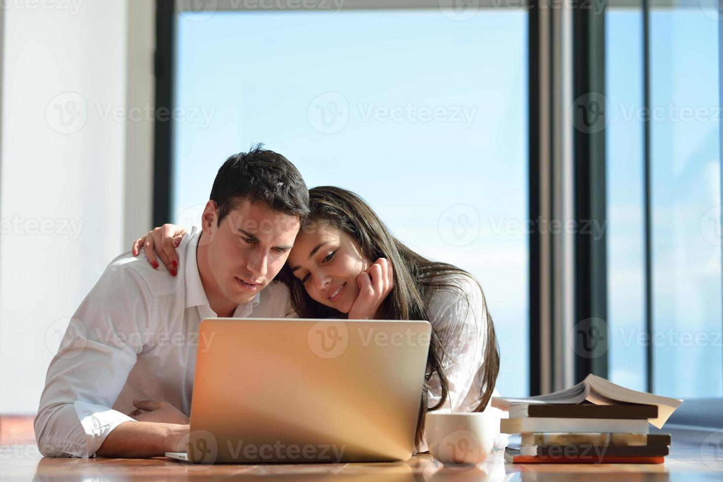 relaxed young couple working on laptop computer at home photo