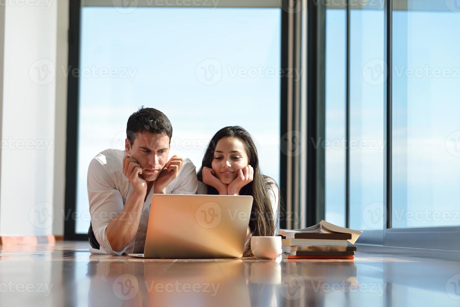 relaxed young couple working on laptop computer at home photo