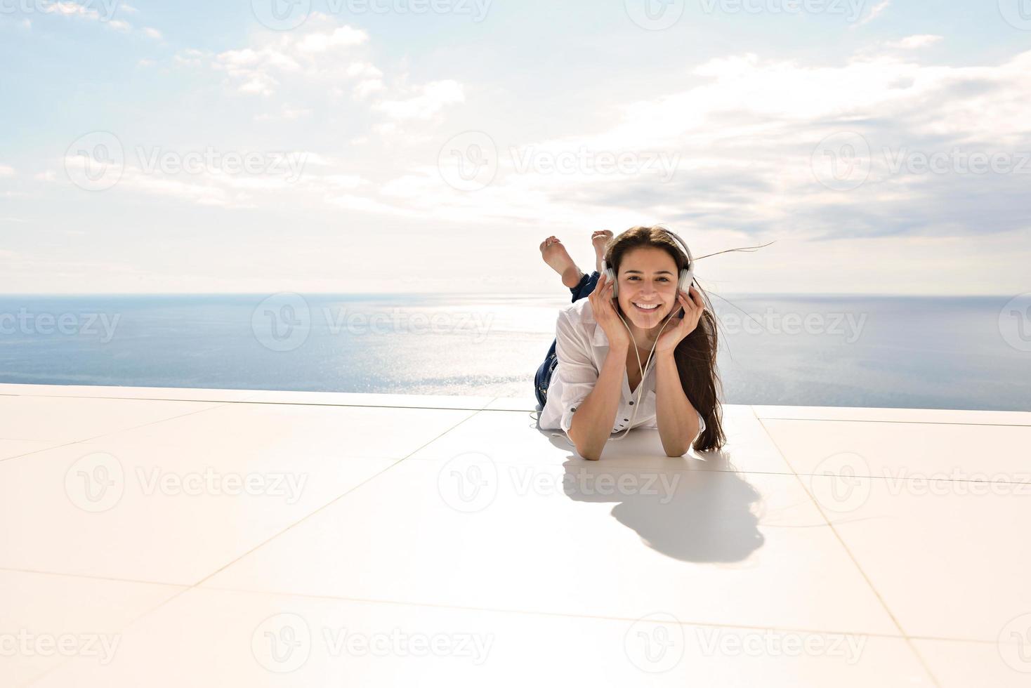 girl listening to the music on white headphones photo