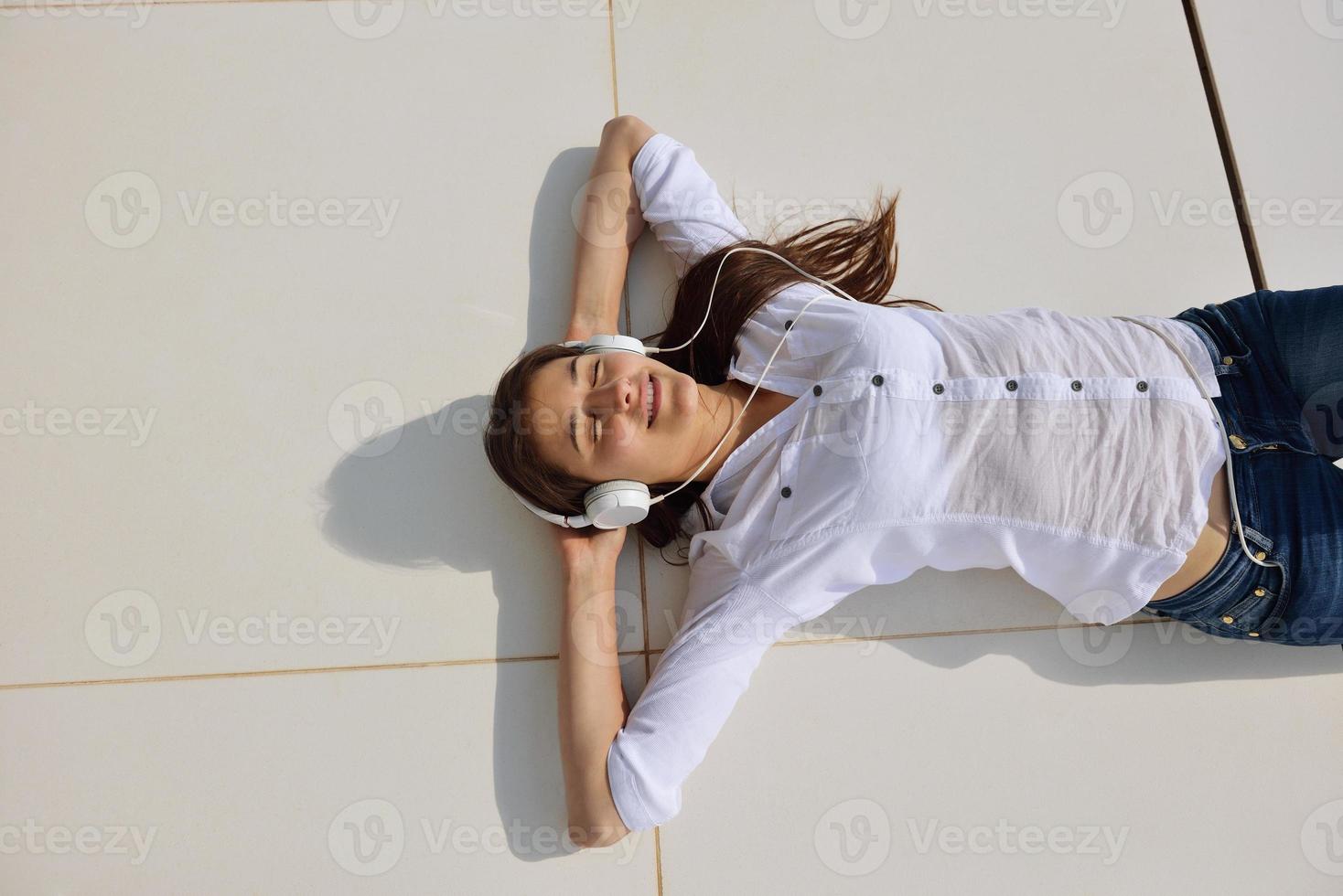 girl listening to the music on white headphones photo
