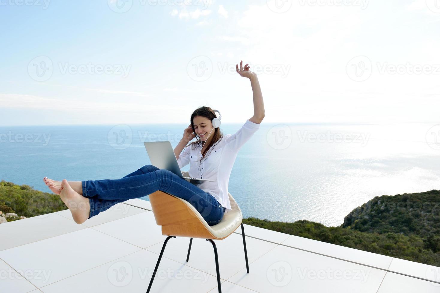 relaxed young woman at home working on laptop photo