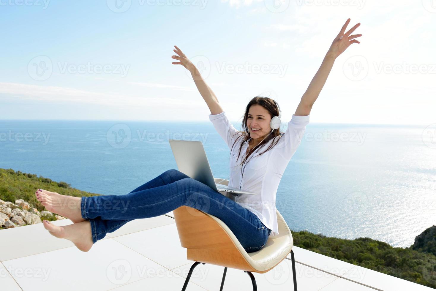 relaxed young woman at home working on laptop photo