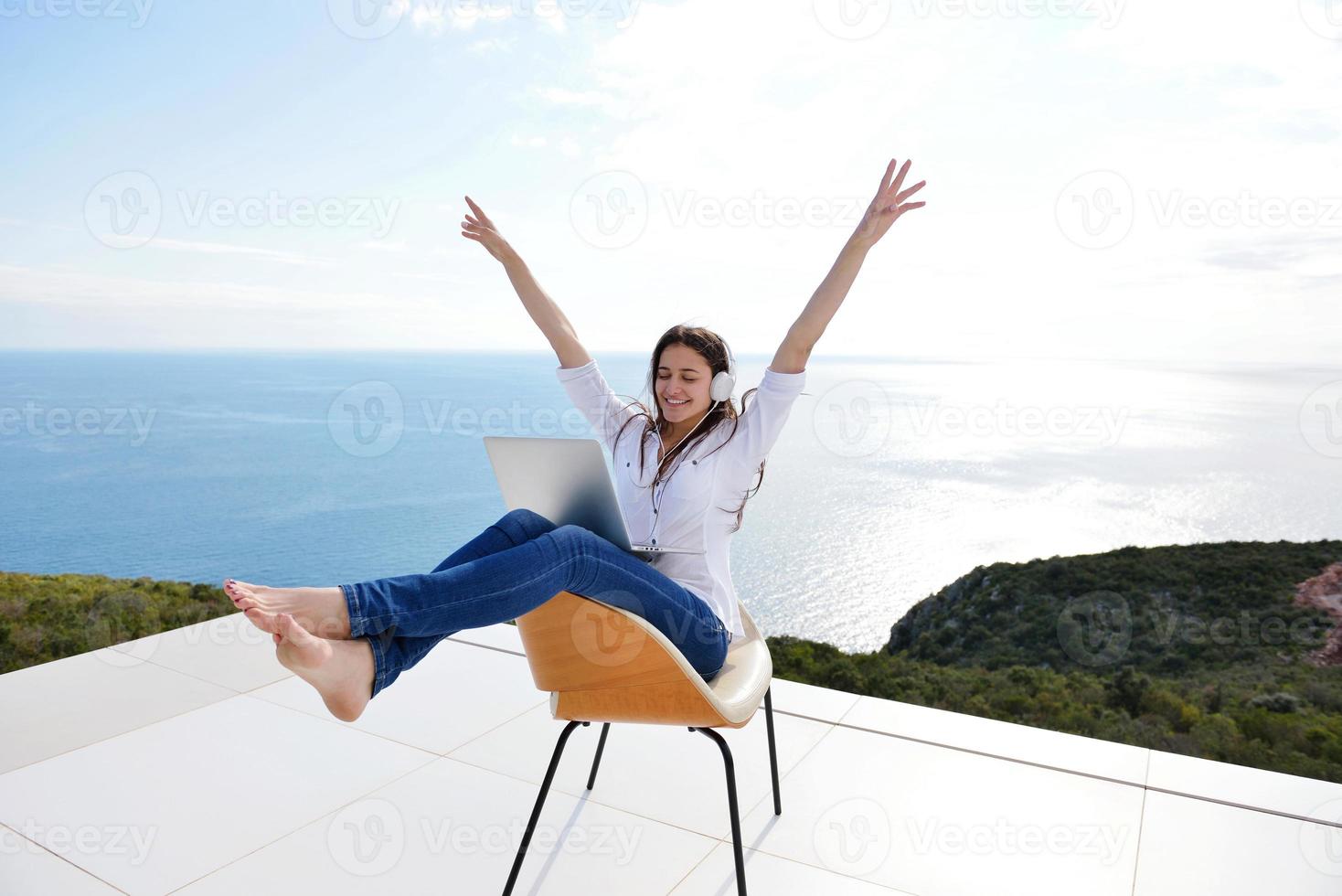 relaxed young woman at home working on laptop photo