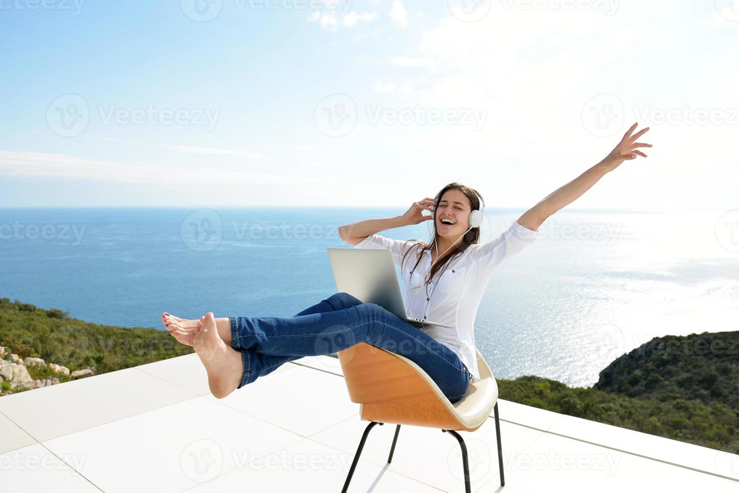 relaxed young woman at home working on laptop photo