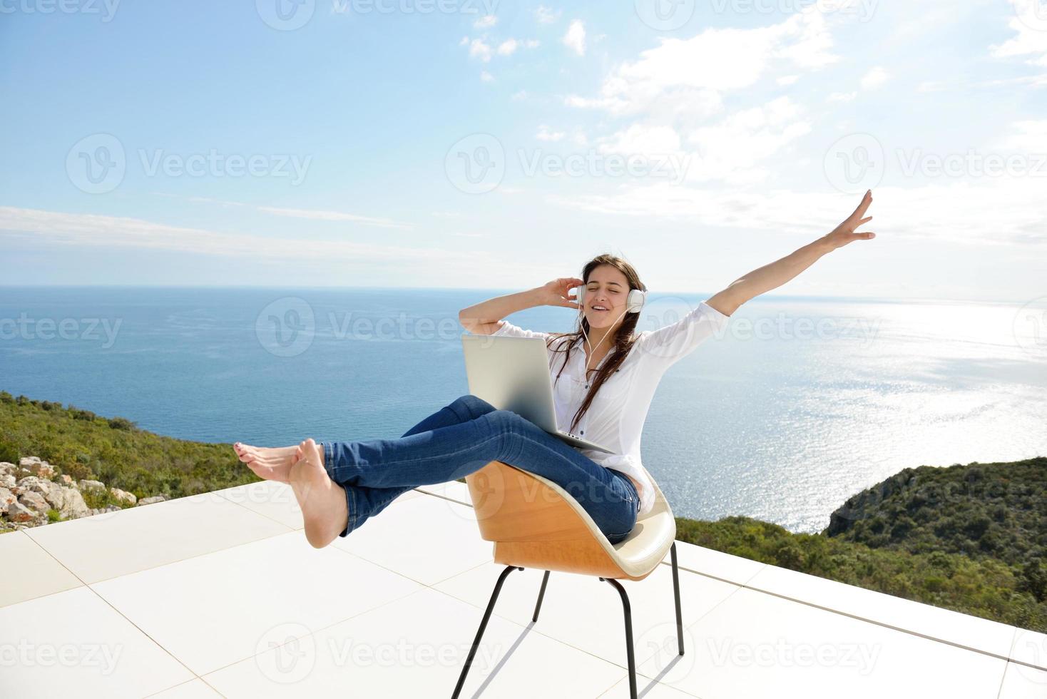 relaxed young woman at home working on laptop photo