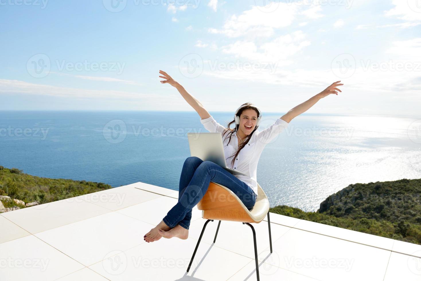 relaxed young woman at home working on laptop photo