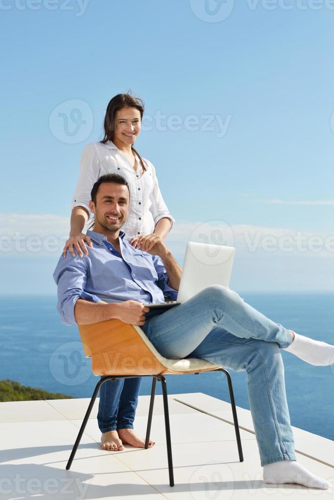 relaxed young couple working on laptop computer at home photo