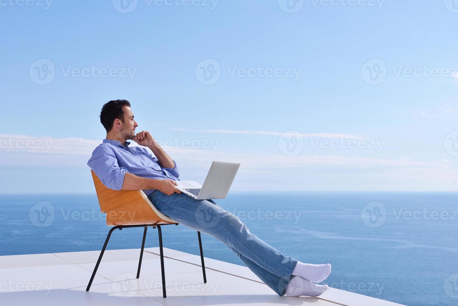 relaxed young man at home on balcony photo