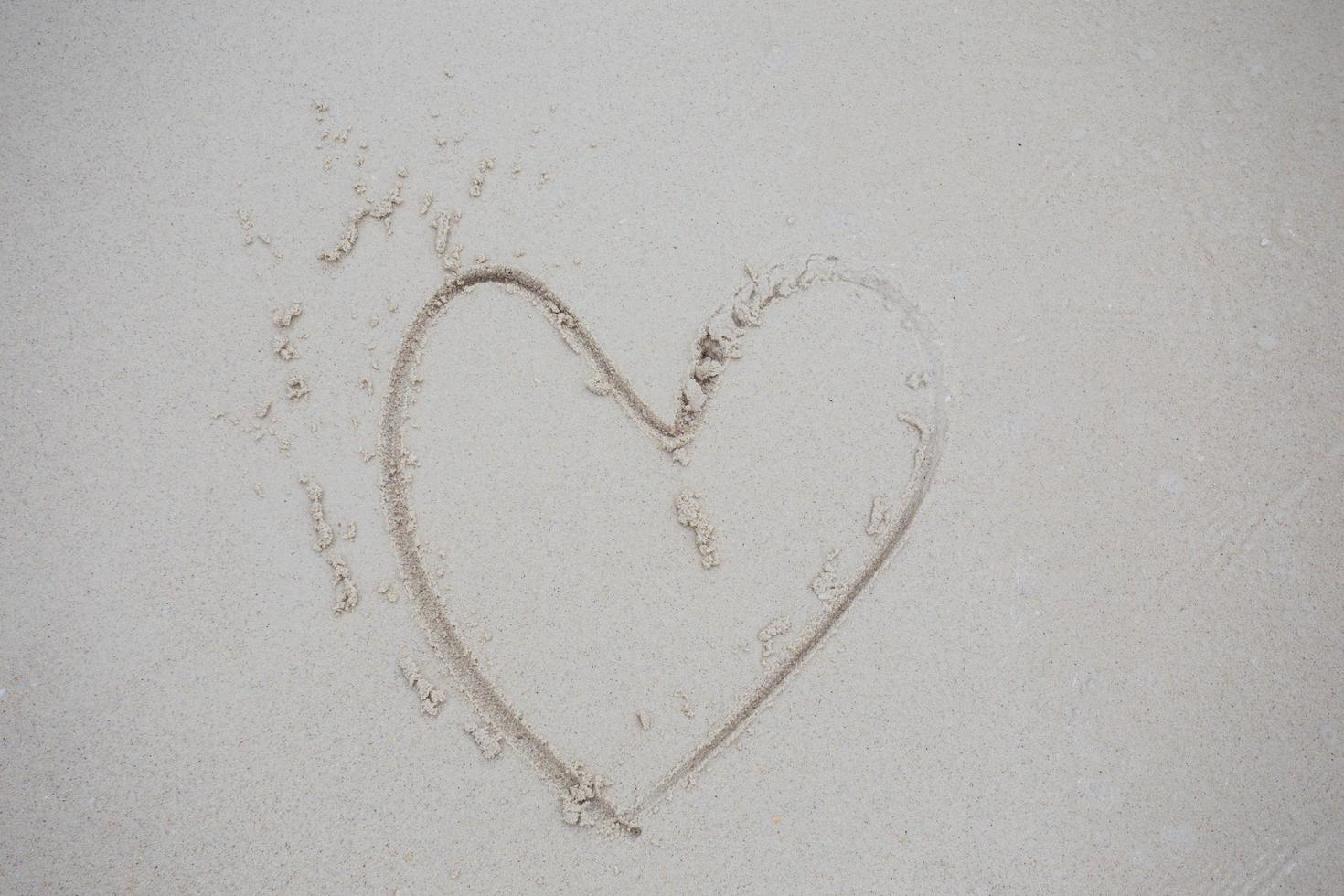 Heart drawn on sand photo