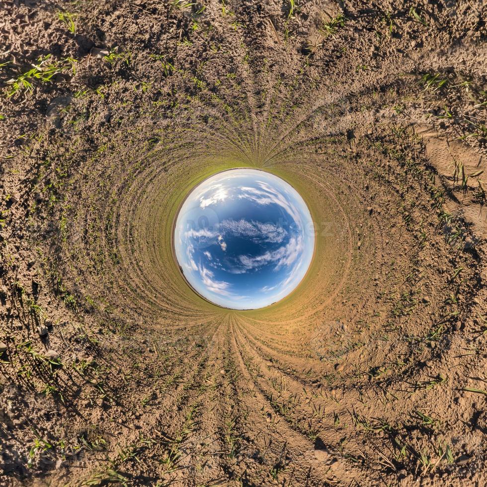 Inversion of little planet transformation of spherical panorama 360 degrees. Spherical abstract aerial view in field with awesome beautiful clouds. Curvature of space. photo