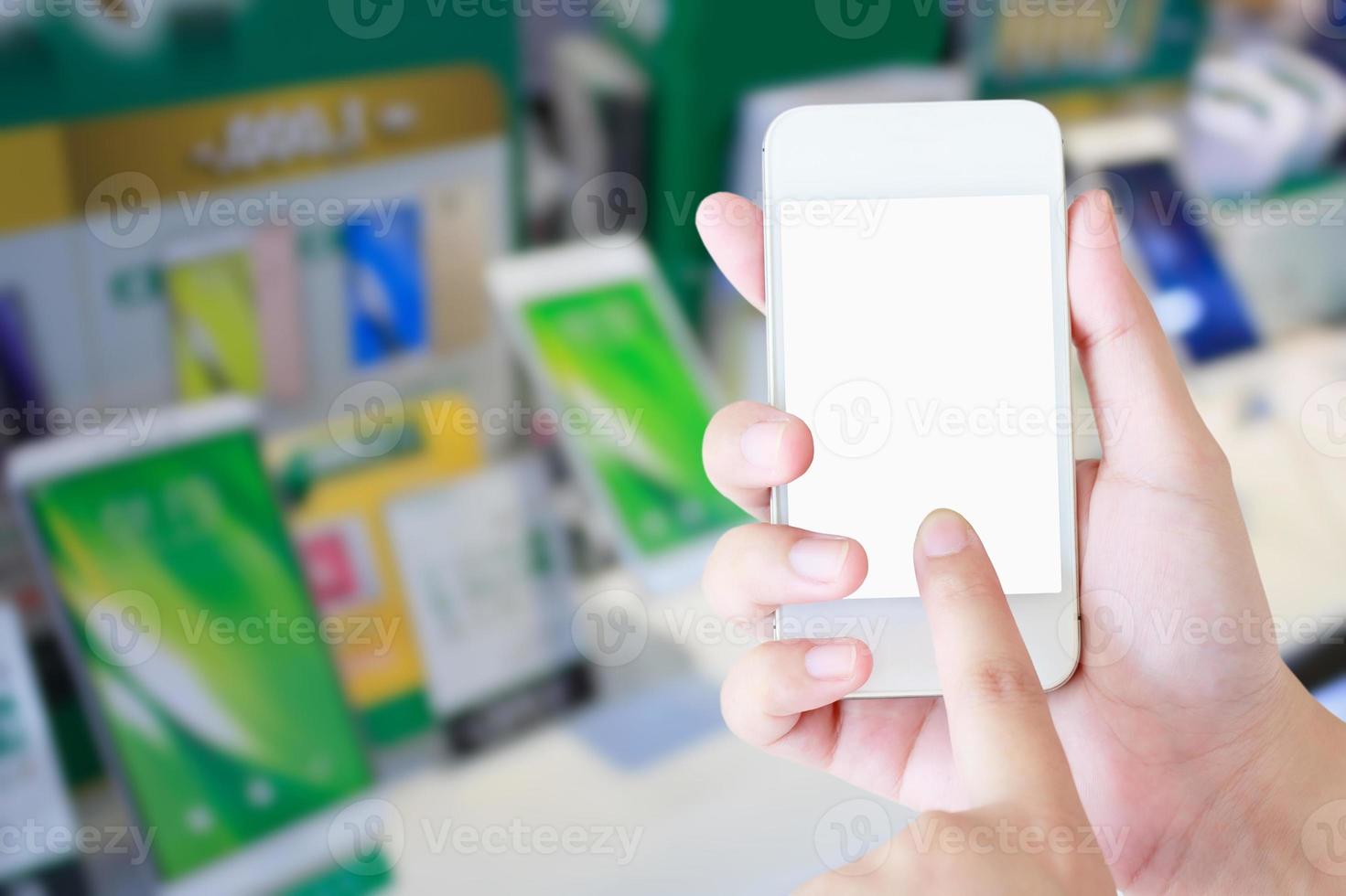 mano femenina sosteniendo un teléfono inteligente móvil a través de una tienda de teléfonos foto