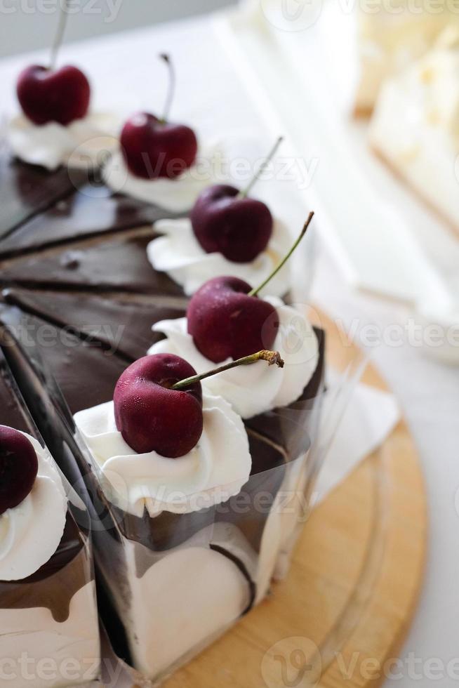Chocolate Whipped Cream Cake with fresh cherry on the table. Homemade bakery concept photo