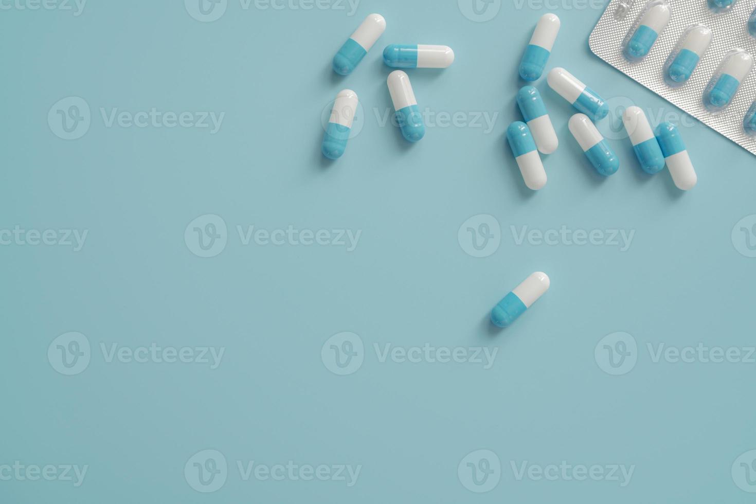 Antibiotic capsule pills on blue background. Prescription drugs. Blue-white capsule pills. Antibiotic drug resistance concept. Pharmaceutical industry. Superbug problems. Medicament and pharmacology. photo