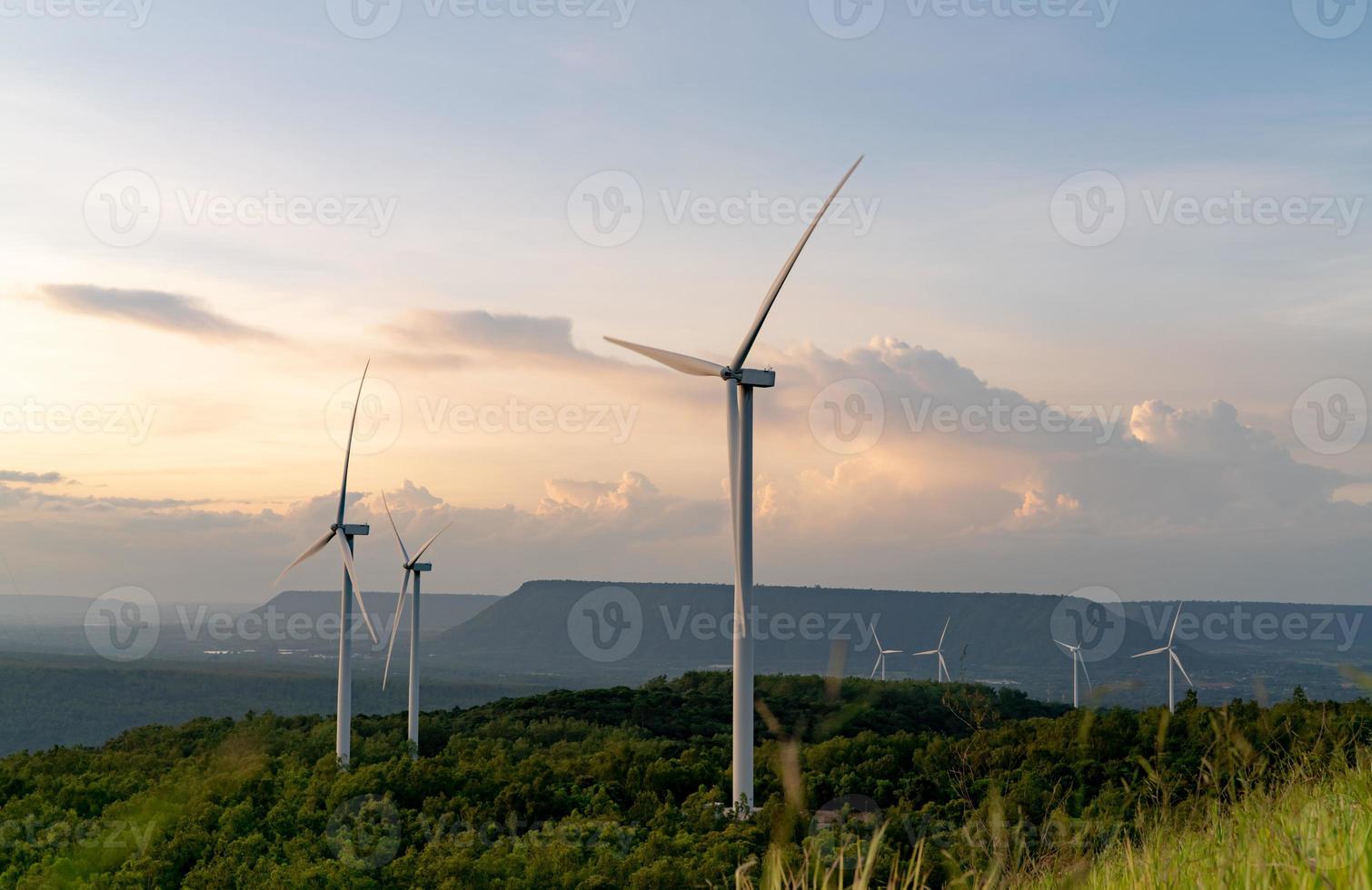 Wind energy. Wind power. Sustainable, renewable energy. Wind turbines generate electricity. Windmill farm on mountain with sunset sky. Green technology. Renewable resource. Sustainable development. photo