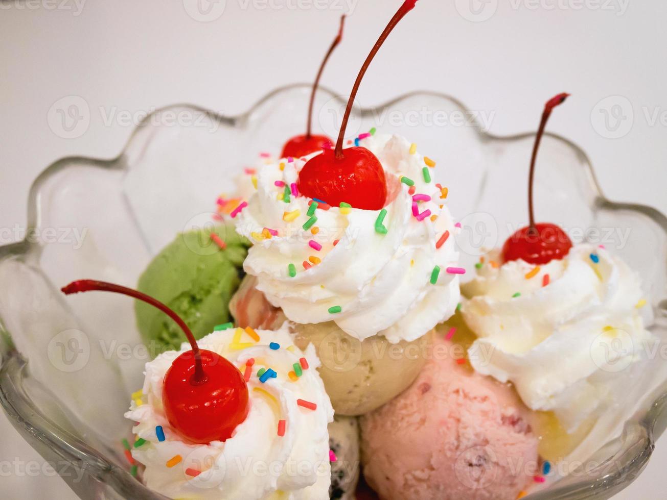 Ice cream scoops with cherry and whipped cream photo