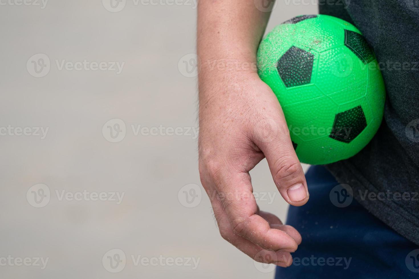 The Green Rubber football toy was held in the male's hand photo
