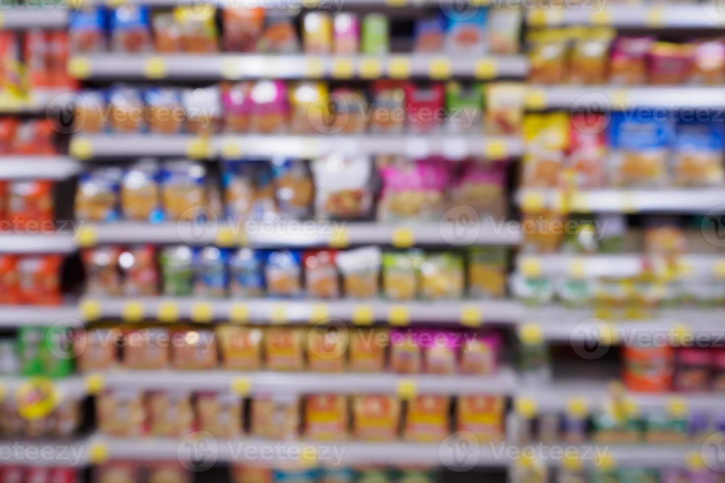 Abstract blur supermarket with variety of snacks chips food product on the shelves in store photo