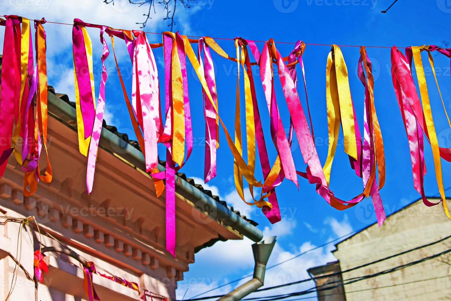 Festive decoration of the city street. Bright, early-colored ribbons are tied on a stretched rope photo