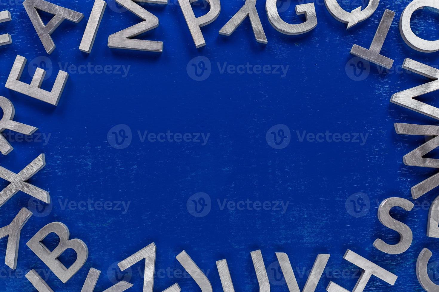 Frame mockup made of of silver metal english alphabet characters on blue background. photo