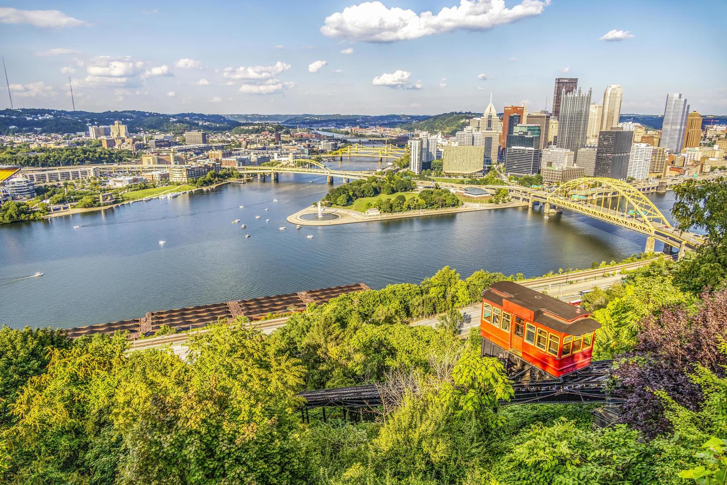 Red tram going down an incline in a city photo