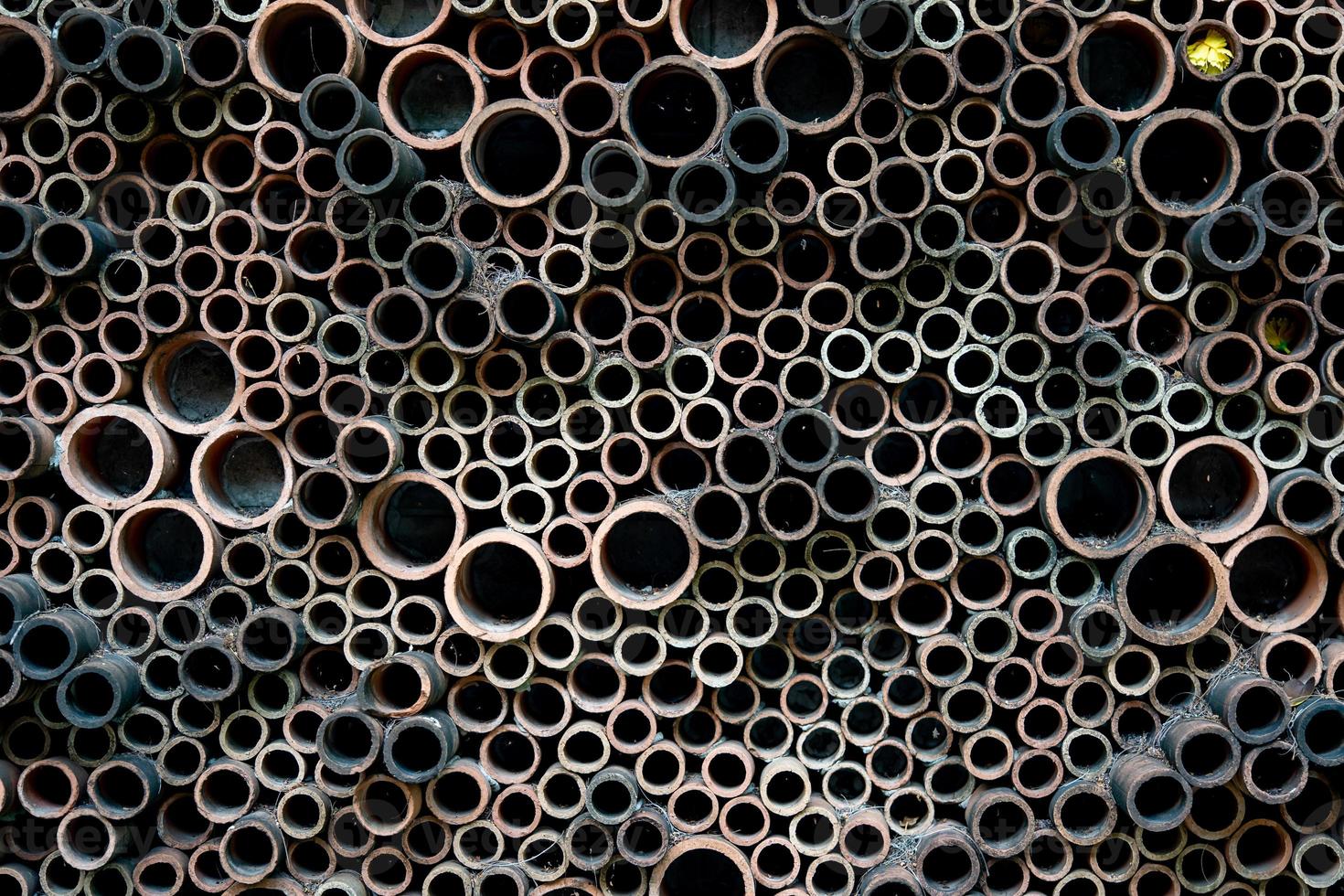 earthenware clay work with the circle tube shap are stick on the wall to the ourdoor art style. photo