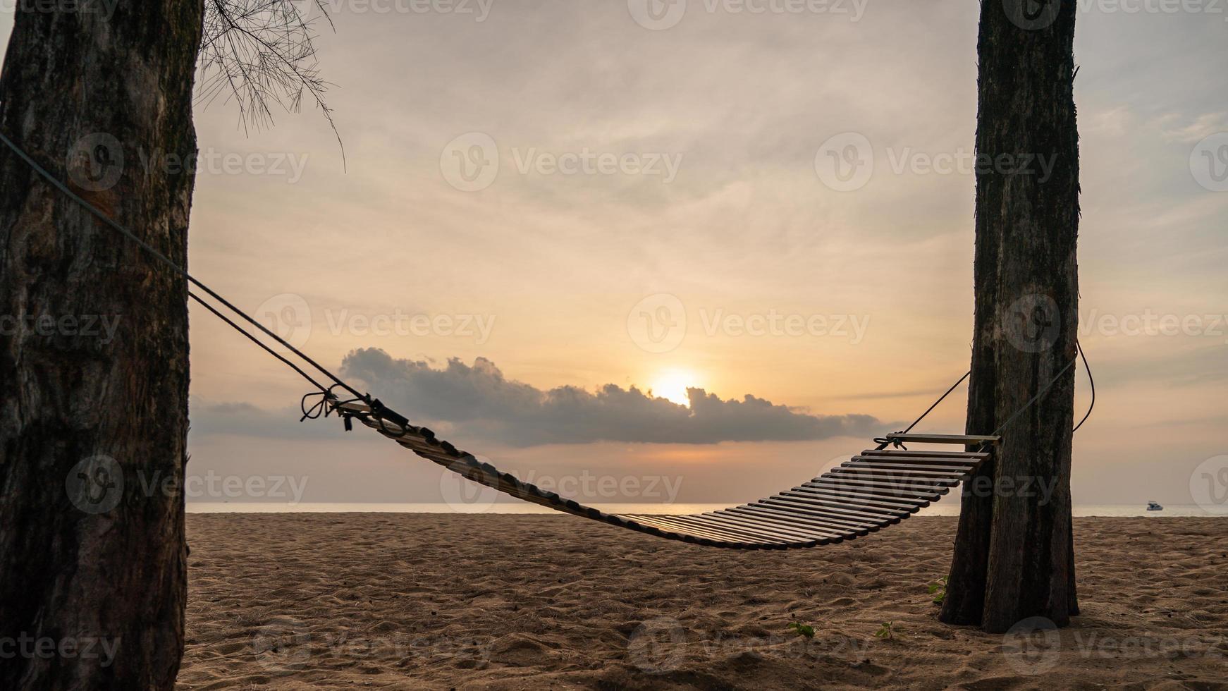 un columpio de madera o una cuna en la playa con hermosas nubes y cielo. foto