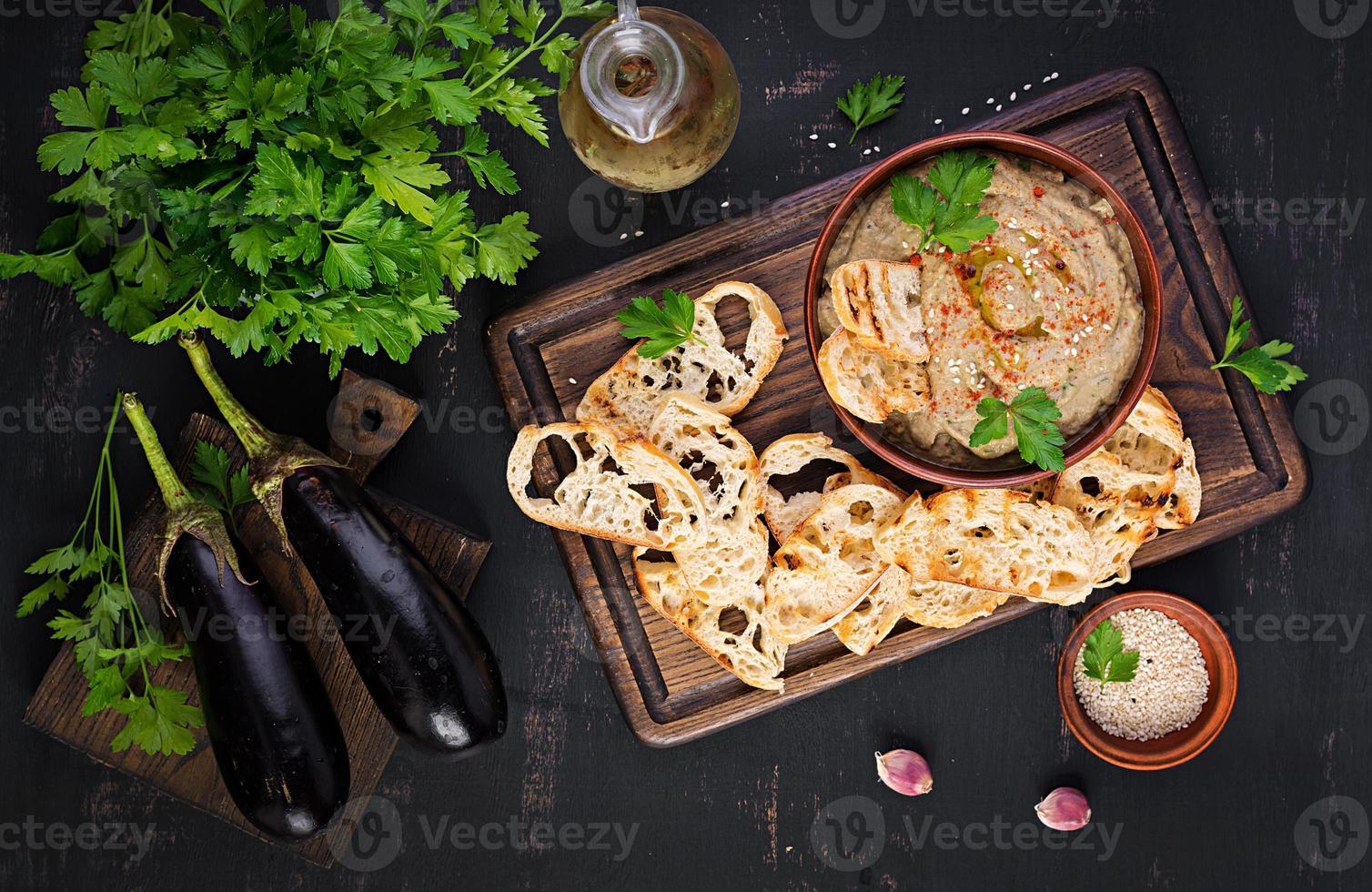 Baba ghanoush vegan hummus from eggplant with seasoning, parsley and toasts. Baba ganoush. Middle Eastern cuisine. Top view, overhead photo