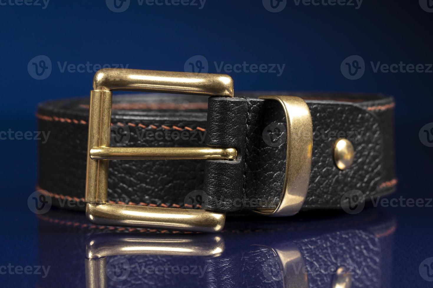 Black leather belt on a dark blue background. photo