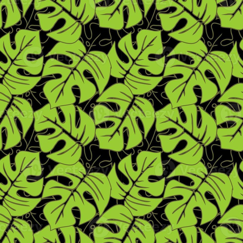 seamless asymmetric pattern of green tropical leaves on a black background, texture, design photo